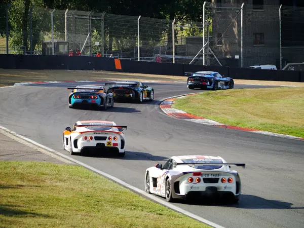 Racing cars rounding a bend on a motor racing circuit