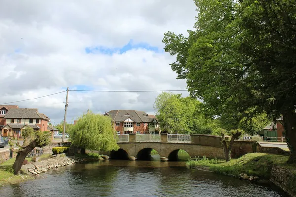 Stone bridge over a river with willows on the banks
