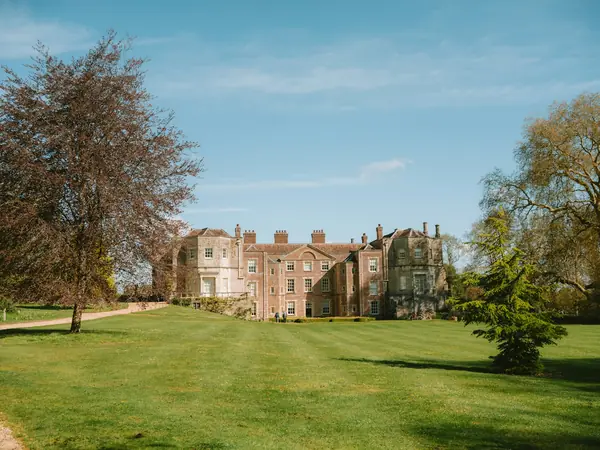 Country house set back across a wide lawn with trees