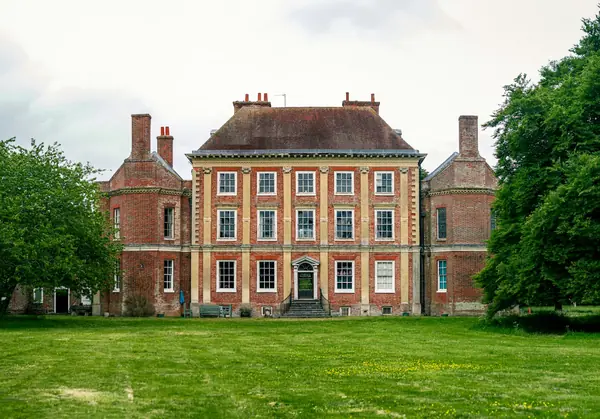 Red brick country house seen across a lawn