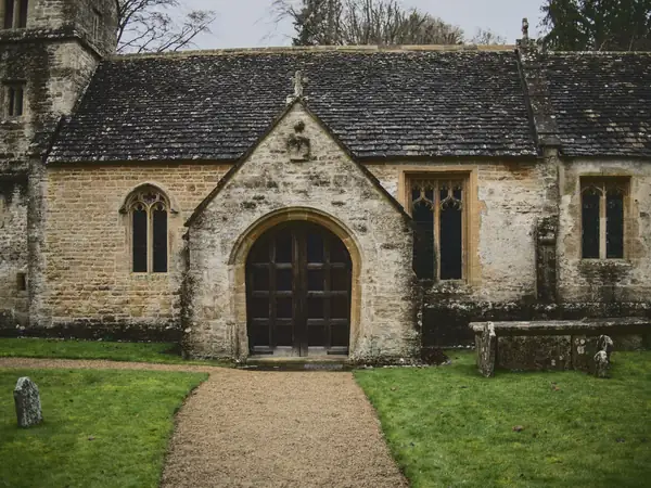 Stone church porch and path through a mown churchyard