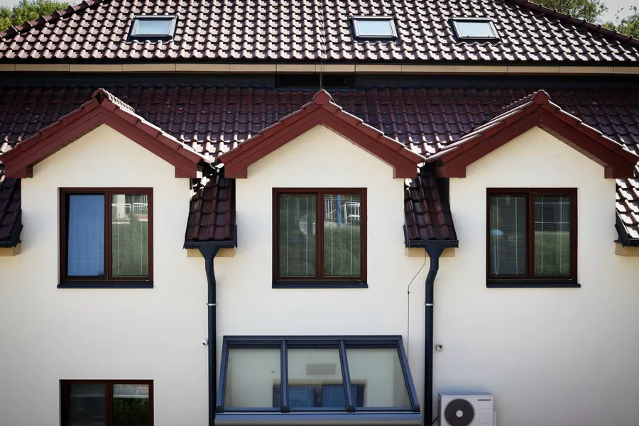 Concrete tiled roof with small front gables, verges and downpipes on a modern house, typical of ridge and verge repairs in Dartford