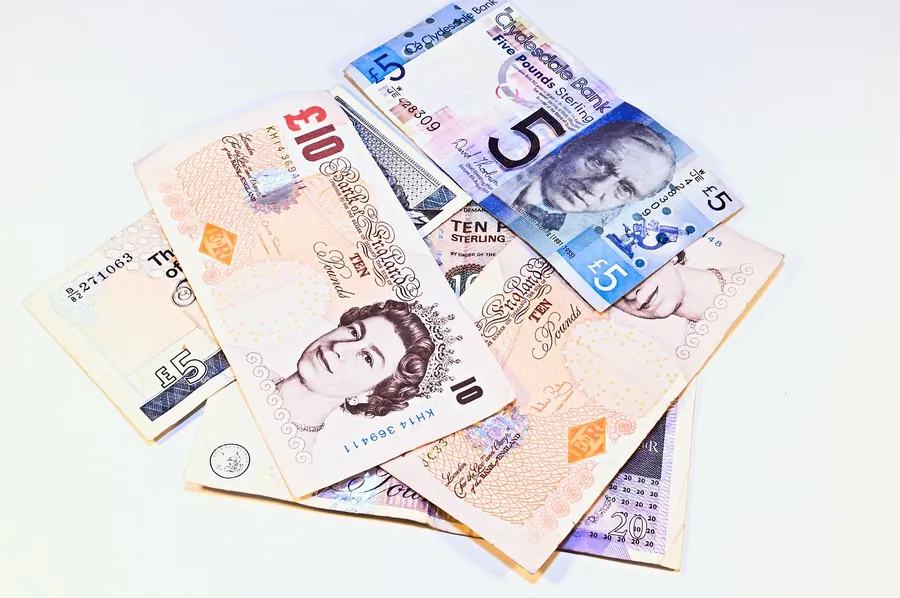 British five and ten pound notes fanned out on a white surface, the cash payment storm-chasing traders ask for