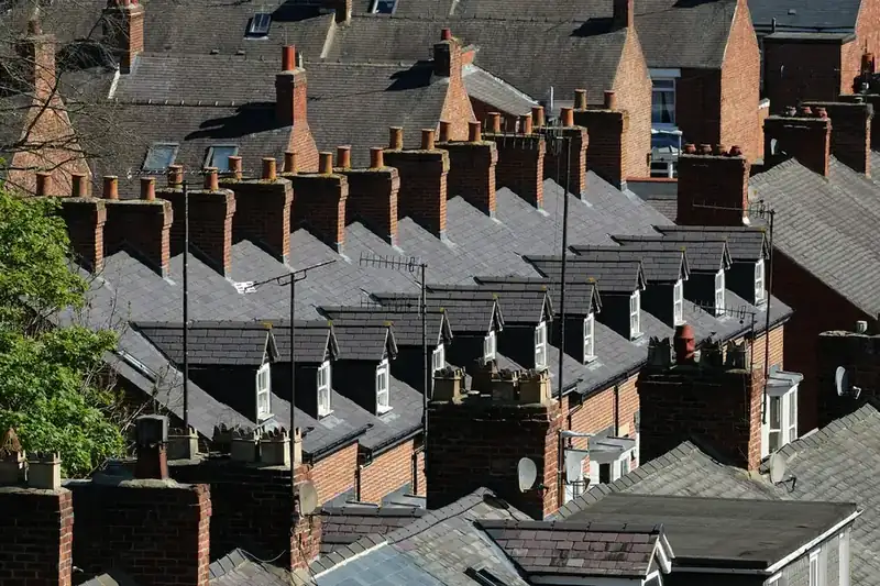 Rows of Victorian terrace roofs with brick chimney stacks and slate coverings, the house type behind most town centre re-roofs in Dartford