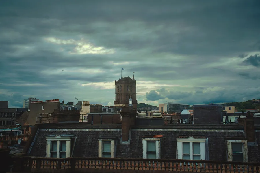 Heavy grey storm clouds gathering over rooftops and chimney stacks