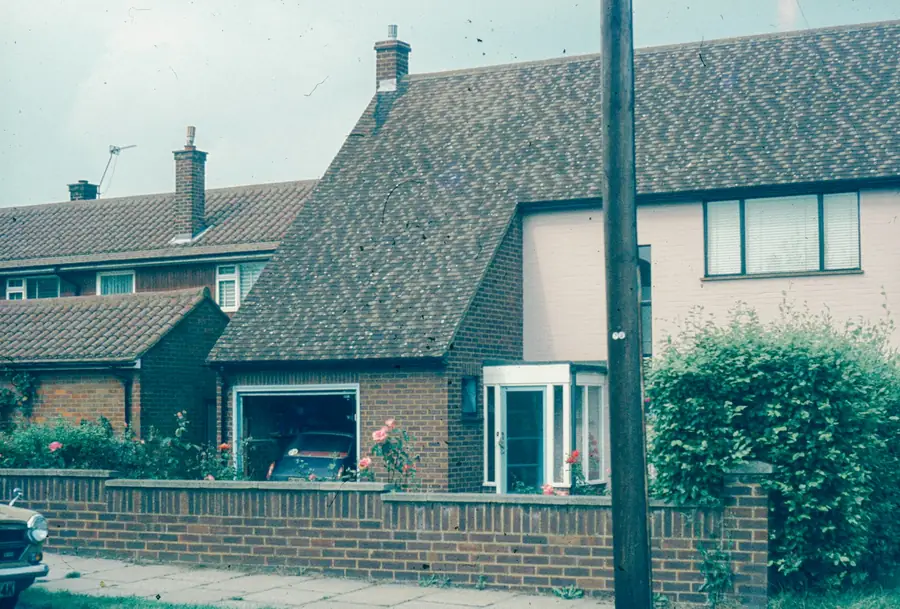 Post-war semi-detached house with a tiled roof behind a low brick wall