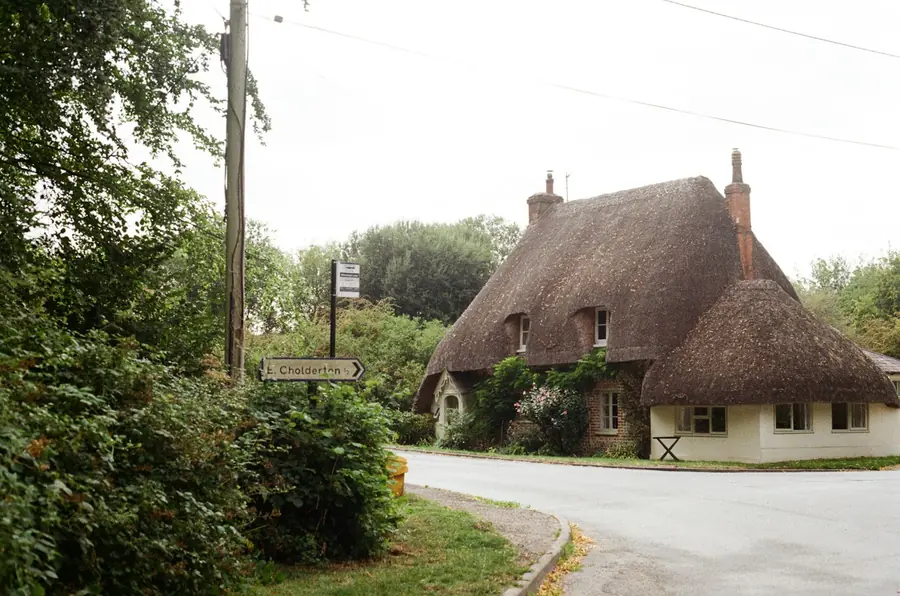Thatched cottage by a roadside bend