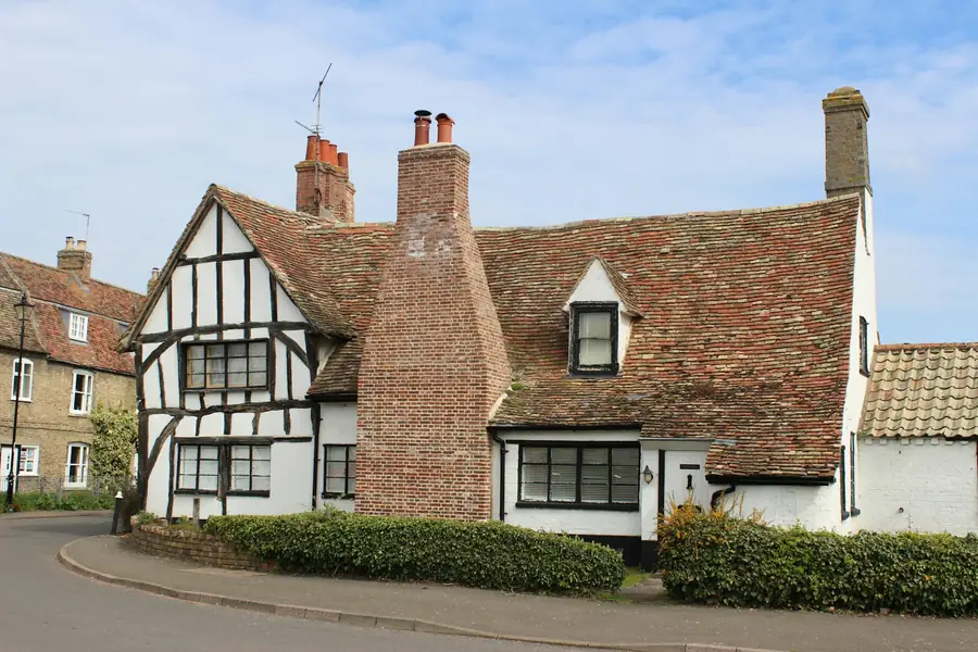 Timber-framed house with a clay tile roof and large brick chimney