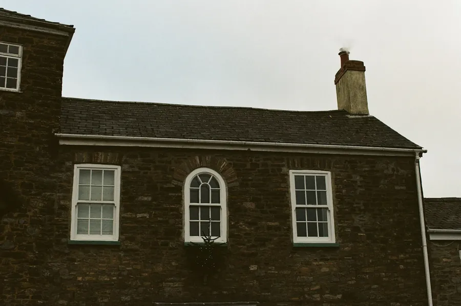 Brick house with a slate roof and chimney stack