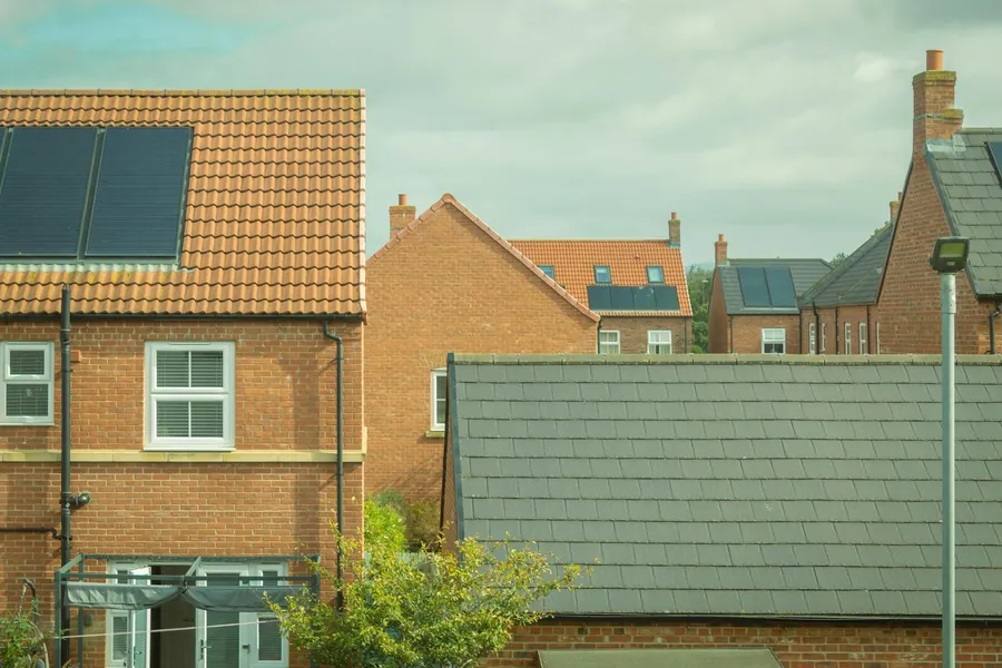 Newer brick houses with tiled roofs, a roof window and solar panels