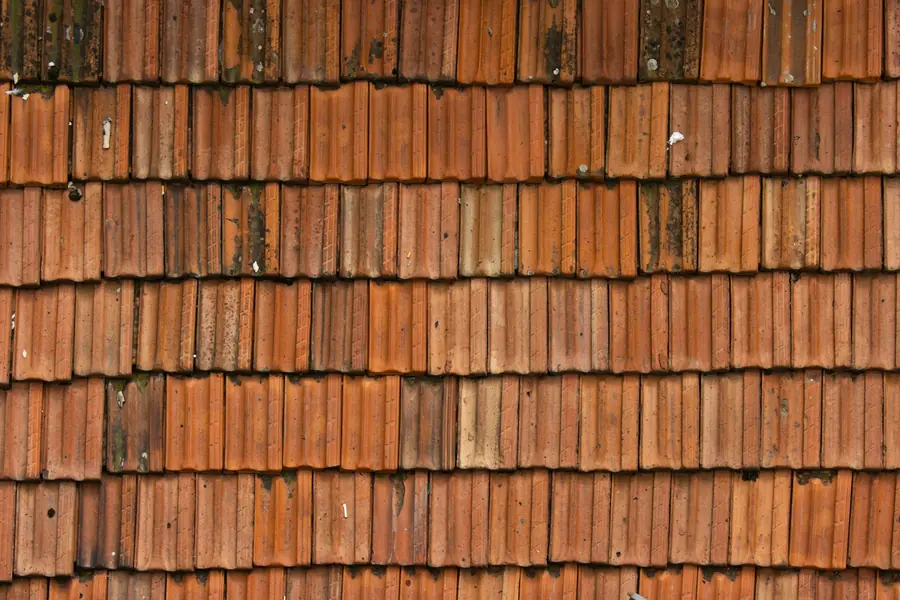 Close-up of weathered red clay roof tiles laid in overlapping courses